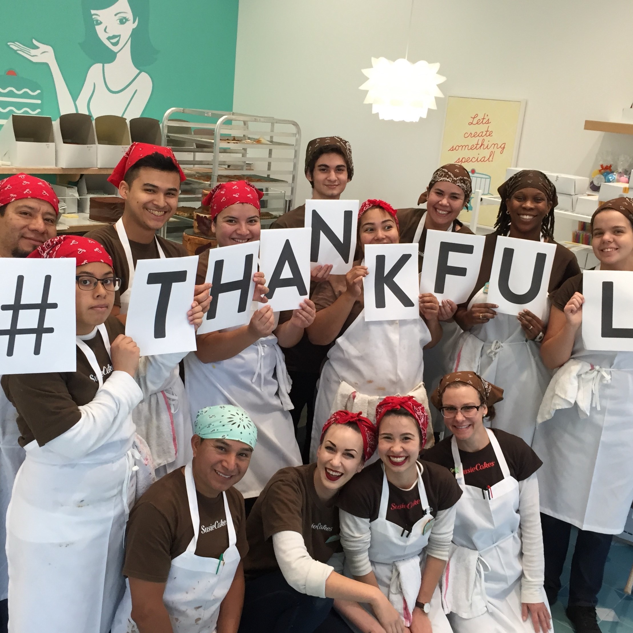 Kitchen staff holding "#THANKFUL" signs