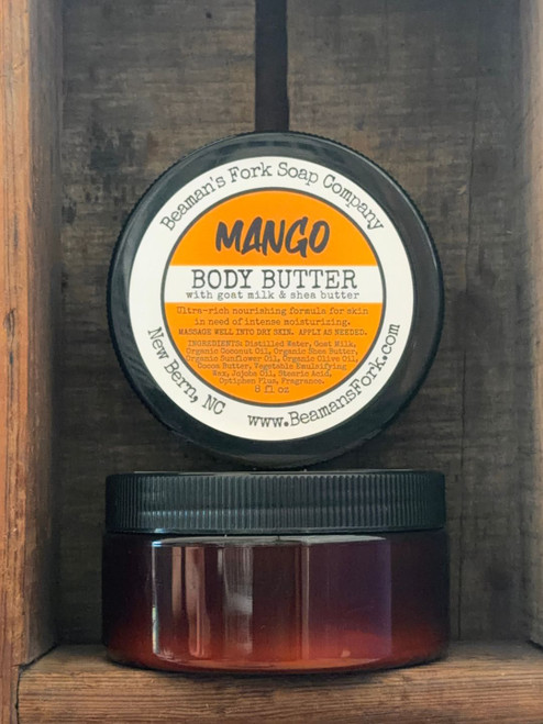 Jar of Mango Scented Goat Milk Body Butter on a rustic wood table