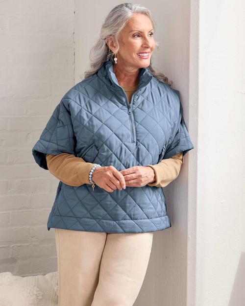 Woman wearing a blue quilted poncho. View Product Image