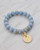 Blue angelite bracelet featuring soft blue stones and an 18k gold-plated hammered charm. View Product Image