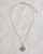Gold pave crystal necklace with turquoise on a marble surface. View Product Image