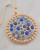 Golden earring adorned with shimmering blue crystals, highlighting elegant crystal pavé earrings. View Product Image