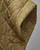 Close-up of a khaki quilted poncho cape  with diamond stitching and a button detail. View Product Image