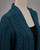 Teal long merino wool cardigan with cable knit detail on mannequin. View Product Image