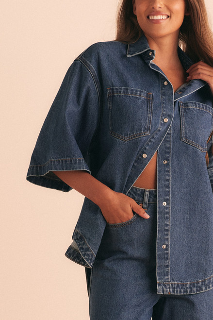 A cool classic, this oversized denim shirt channels effortless casual with a soft curve hem, chest patch pockets, and short sleeves. Made from premium cotton denim with just the right weight, it’s a wardrobe essential that pairs beautifully with everything from shorts to tailored pants.