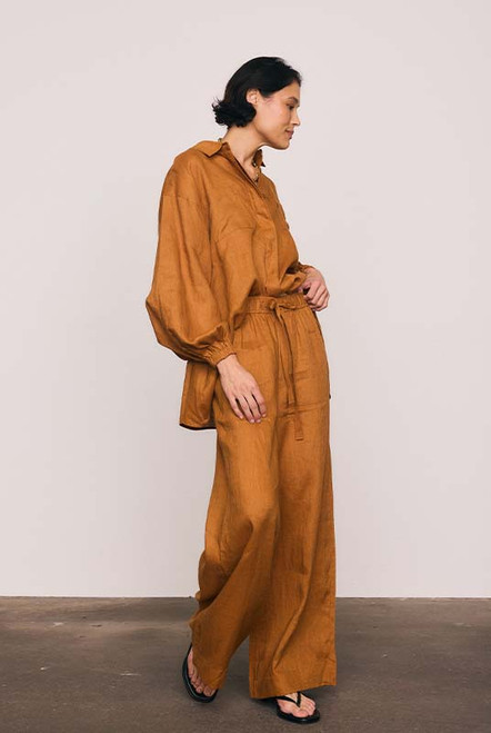 These rust linen wide-leg pants combine effortless comfort with elevated tailoring. The elasticated waist with drawcord and side pockets create a laid-back yet polished silhouette, perfect for both sunlit mornings and twilight dinners. Wear with the Rust Billow Shirt for easy, relaxed style.