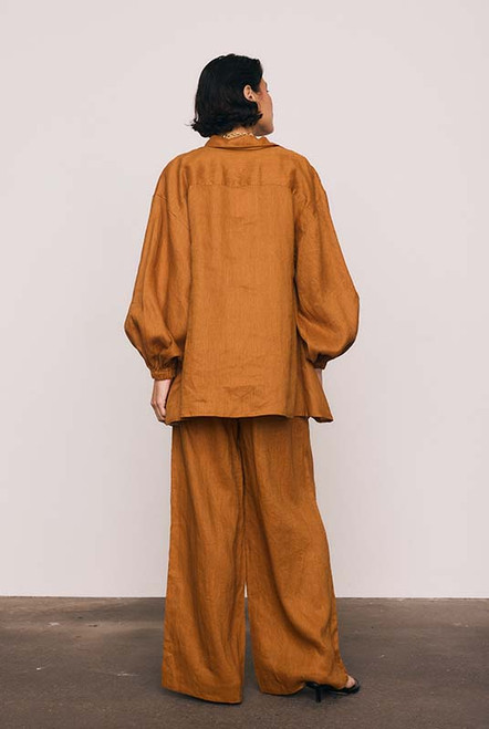 These rust linen wide-leg pants combine effortless comfort with elevated tailoring. The elasticated waist with drawcord and side pockets create a laid-back yet polished silhouette, perfect for both sunlit mornings and twilight dinners. Wear with the Rust Billow Shirt for easy, relaxed style.