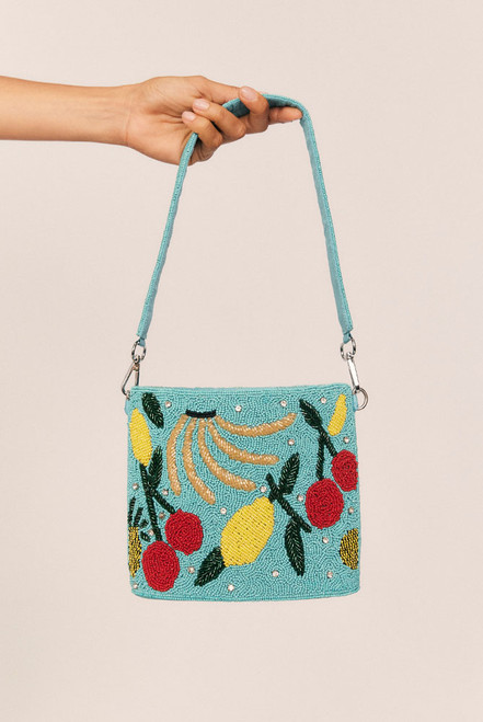 A joyful celebration of craftsmanship, the Fruity Beaded Handbag is an artisanal piece that turns every outfit into a statement. Featuring a hand-beaded fruit motif, multi-coloured tassels, and a removable wide shoulder strap—also intricately beaded—this compact carryall is full of character.