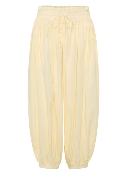 Breezy, billowing, and beautifully undone. The Genie Pant in soft Buttermilk is your invitation to float through the day with ease. Crafted from lightweight cotton voile, this ankle-grazing silhouette features a smocked elastic waist and cuffs for all-day comfort, while a waist drawcord and side seam pockets add subtle functionality.
