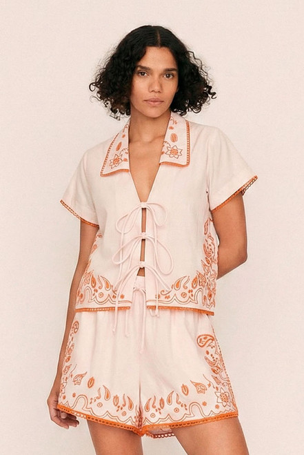 Sweet yet spirited, the Bonnie Embroidered Top is a cropped cotton poplin blouse brought to life with bold, artisanal embroidery. Set against a dreamy pastel pink base, vibrant orange threadwork creates a striking contrast—evoking a sense of playful femininity with a handcrafted feel.