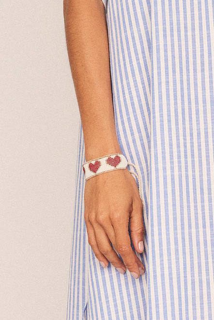 Sweet and striking, the Loveheart Beaded Bracelet is an artisanal piece that adds charm to every wrist. Hand-beaded in a bold heart design, it features a vibrant mix of red, gold, and white glass beads intricately woven into a timeless symbol of love.
