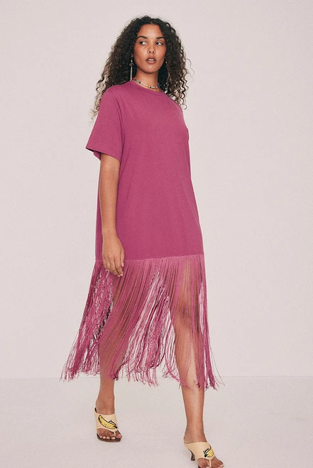 Cut from soft cotton jersey, this magenta T-shirt dress is finished with a playful fringe at the hem that moves as you do. Wear for dinner, and whatever follows it. We know this one will be a best seller, don't sleep on it. Get yours before it's gone. Designed from a 6 to a 22.
