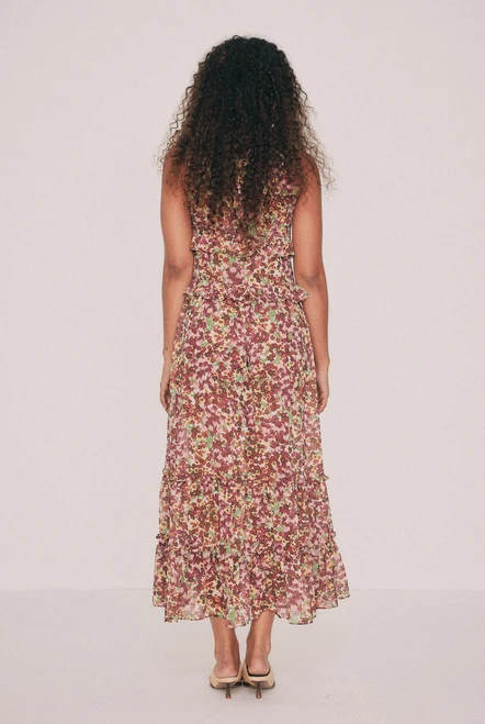 Cut from soft crepe georgette, this printed maxi dress skims the bust and waist before loosening through the hip. Ruffles run beneath the bust, at the waist and along the hem, while a low V neckline ties at the front with self rouleau. The Ola ditsy floral was drawn by hand in our Central Coast studio. Pockets sit in the side seams. A wedding guest dress that will also carry a long lunch. Pair with a vintage platform and chandelier earrings. Designed from a 6 to a 22.
