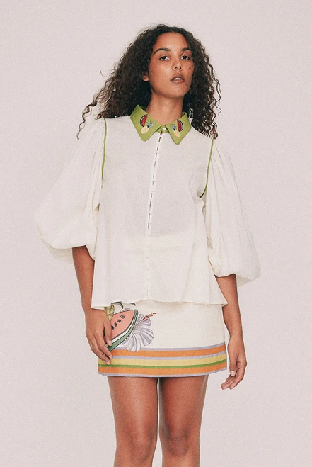 Cut from soft cotton voile, this cream blouse is finished with an embroidered collar designed in our Central Coast studio. Long puff sleeves gather at an elasticated cuff and the front buttons the whole way down. Tuck it into the Tropicana mini skirt, or wear it loose over denim shorts for a more casual approach. True to size, designed from a 6 to a 22.
