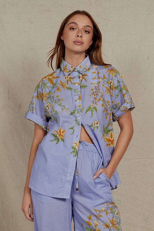 This short sleeve 'Zinnia' shirt is printed with a delicate floral motif on a vibrant periwinkle backdrop. Cut from cotton voile, it has a relaxed fit, dropped shoulders and a neat collar. Wear yours with anything from the co-ord pants to your favourite denim cut-offs.