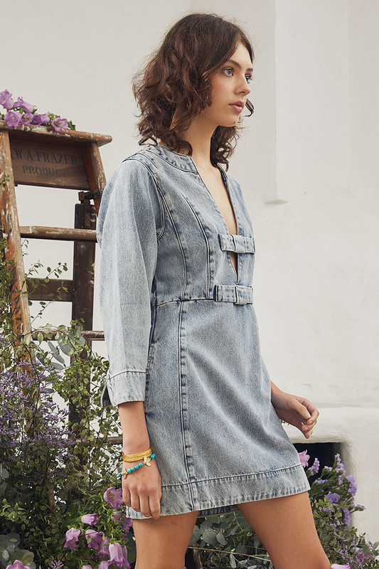 This update on the classic denim mini dress is effortlessly cool. It has a long sleeve design with structural seams through the waist and panels at the back for a slim fit. The front neckline is adorned with tonal denim bows. Wear yours with sandals or gazelles.