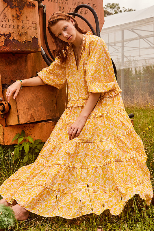 From the honey tones to the fluttery tiers, Bohemian Traders Ruffle Neck Maxi Dress is destined to be the centre of attention. It's made from cotton voile that's printed with 70's inspired florals and has tonal ties to the neck. Pair yours with tan accessories for day and golden heels for night.