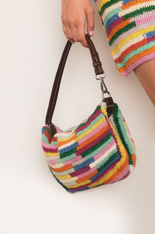 A burst of colour and craft, this cotton crochet mini bag features a zipper closure with leather tassel and straps. Lightweight and artisanal, it’s the perfect playful companion for casual days and festival nights.