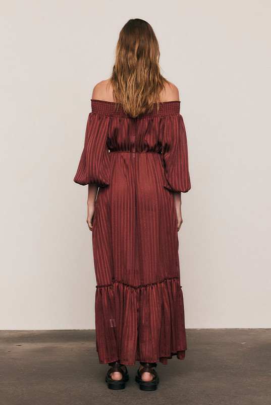 Luminous and luxurious, the Lurex Maxi Dress is crafted from a custom-dyed lurex-stripe blend, developed exclusively to Bohemian Traders’ exacting standards. Its off-shoulder neckline, voluminous balloon sleeves, and waist tie create a silhouette of effortless drama. Light-catching and fluid, it moves like liquid sunlight - a true statement of artistry and occasion-ready elegance.