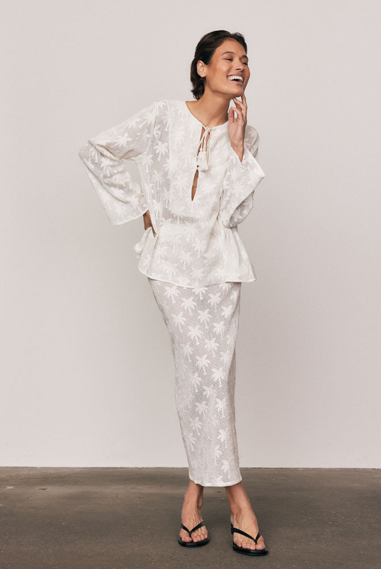 The Cotton Lace Maxi Skirt captures quiet elegance in motion. Cut from a premium cotton-blend knit lace with a refined palm motif, it’s designed with an elasticated waist and fluid drape that flatters effortlessly. Wear it with the matching Cotton Lace Swing Top for a feminine, textural look that feels timeless and beautifully modern.