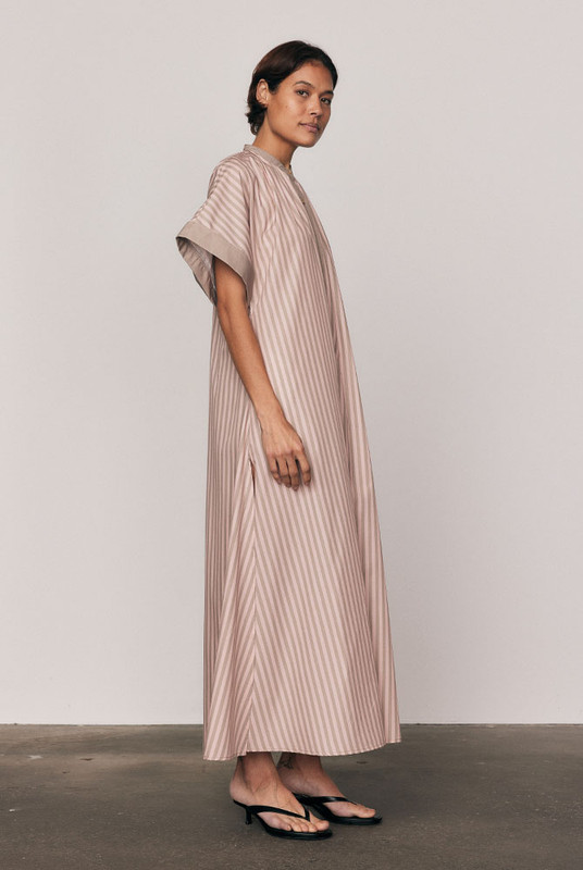 Crisp cotton poplin meets effortless movement in the Maxi Smock Dress. Showcasing Bohemian Traders’ custom pink striped print, this dress balances structure with ease through wide sleeves and a fluid silhouette. Designed to flatter every form, it’s the ultimate throw-on piece for sunny days and easy evenings.