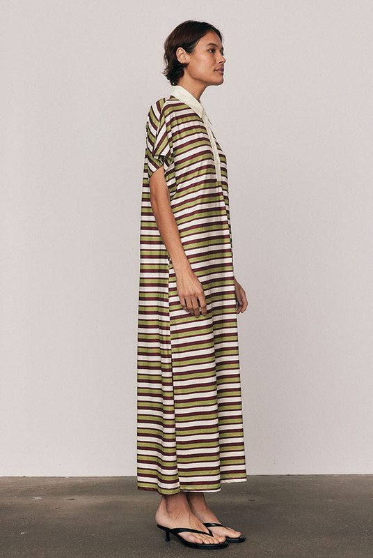 The Maggie T-Shirt Dress redefines relaxed polish. Crafted from silky striped polyester, it features a contrast collar, embroidered logo, and fluid drape that moves with ease. Its mid-length silhouette and effortless comfort make it perfect for day-to-night styling. Casual, confident, and crafted for women who favour style with soul.