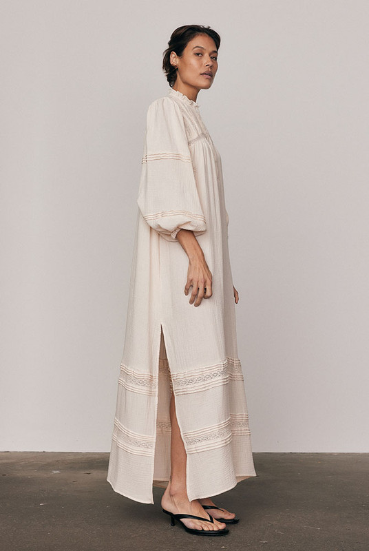 Light, effortless and full of movement, the Kinney Billow Dress is crafted from pure double cotton with delicate lace and pintuck detailing. Featuring a soft ruffle neckline, voluminous sleeves and a flowing silhouette, it drapes beautifully with every step. A timeless expression of bohemian ease. Breathable, versatile and endlessly flattering on every size.