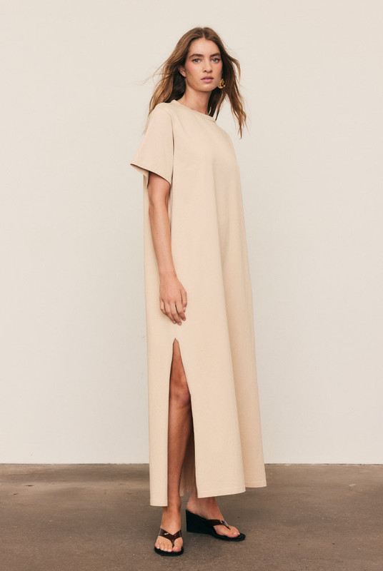 The T-Shirt Dress is crafted from premium pure cotton with subtle logo embroidery, delivering everyday comfort with refined simplicity. Designed in an oversized silhouette with side splits and pockets, it moves effortlessly through the day. Easy to wash and endlessly wearable, this natural-fibre essential defines the art of relaxed, elevated dressing.