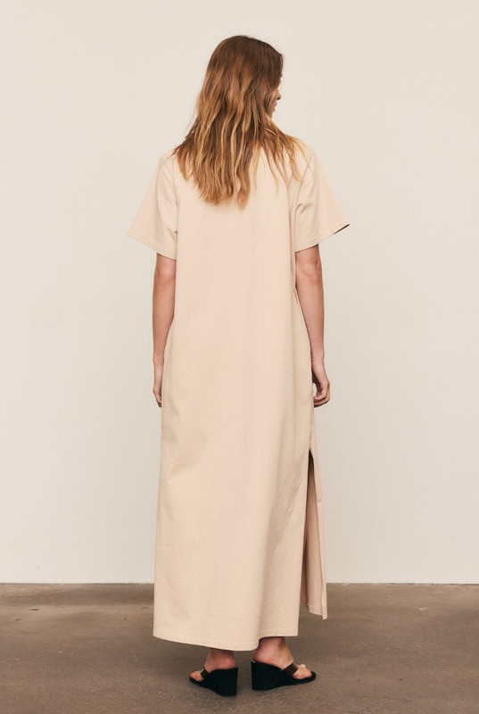 The T-Shirt Dress is crafted from premium pure cotton with subtle logo embroidery, delivering everyday comfort with refined simplicity. Designed in an oversized silhouette with side splits and pockets, it moves effortlessly through the day. Easy to wash and endlessly wearable, this natural-fibre essential defines the art of relaxed, elevated dressing.