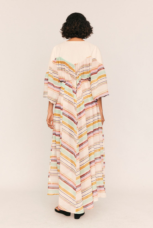 A whisper of nostalgia woven through modern lines, the Marie Sheer Smock Maxi is a poetic ode to sun-drenched Parisian afternoons and quiet femininity. Cut from lightweight crepe georgette with a custom pastel stripe print, this semi-sheer silhouette floats effortlessly with every step. A soft linen yoke and round neckline lend structure, while an elasticated cuff and rouleau waist tie invite softness and shape.