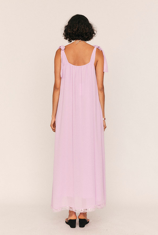 Feminine, flattering, and softly romantic, the Trim Slip Maxi is made for slow afternoons and moonlit evenings. Crafted from lightweight lilac crepe georgette and fully lined in self fabric, it drapes with a gentle swish and a touch of whimsy.