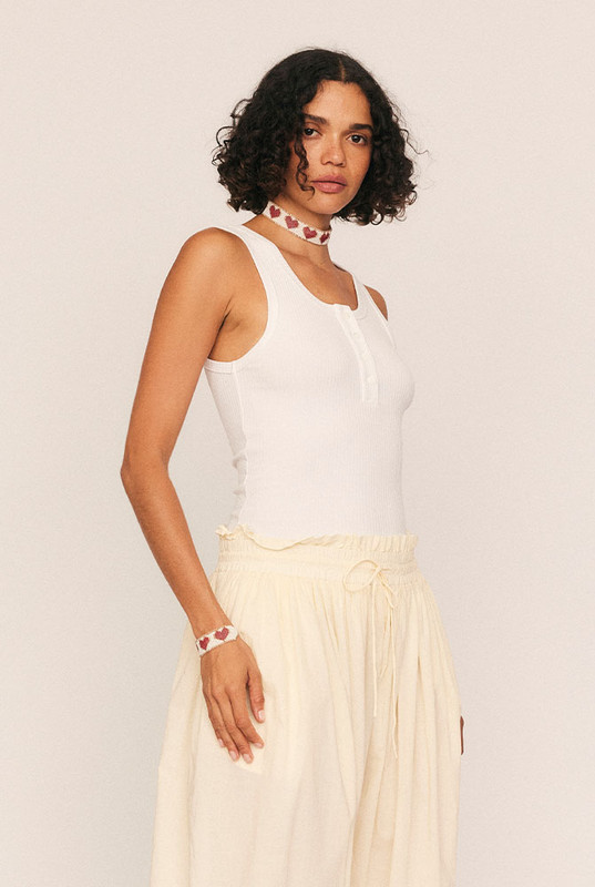 A modern wardrobe essential reimagined with quiet confidence. The Scoop Neck Tank is cut from soft, premium ribbed cotton with just the right amount of stretch, offering a figure-skimming silhouette that flatters every shape. With a rounded scoop neckline, sleek self-binding, and functional button detailing, it transitions effortlessly from layering piece to stand-alone staple.