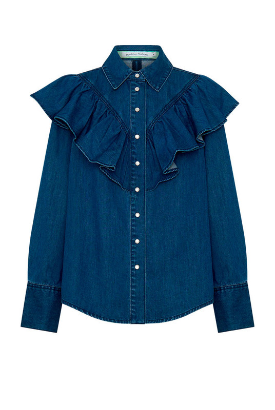 A timeless staple with a romantic edge, the Ruffle Denim Shirt redefines denim shirting with soft structure and thoughtful detail. Crafted from premium mid-weight cotton denim, it features a circular frill tracing the front and back yoke—bringing movement and femininity to a classic silhouette.