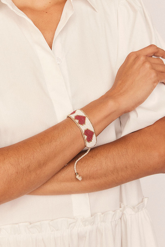 Sweet and striking, the Loveheart Beaded Bracelet is an artisanal piece that adds charm to every wrist. Hand-beaded in a bold heart design, it features a vibrant mix of red, gold, and white glass beads intricately woven into a timeless symbol of love.