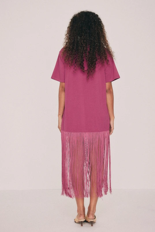 Cut from soft cotton jersey, this magenta T-shirt dress is finished with a playful fringe at the hem that moves as you do. Wear for dinner, and whatever follows it. We know this one will be a best seller, don't sleep on it. Get yours before it's gone. Designed from a 6 to a 22.