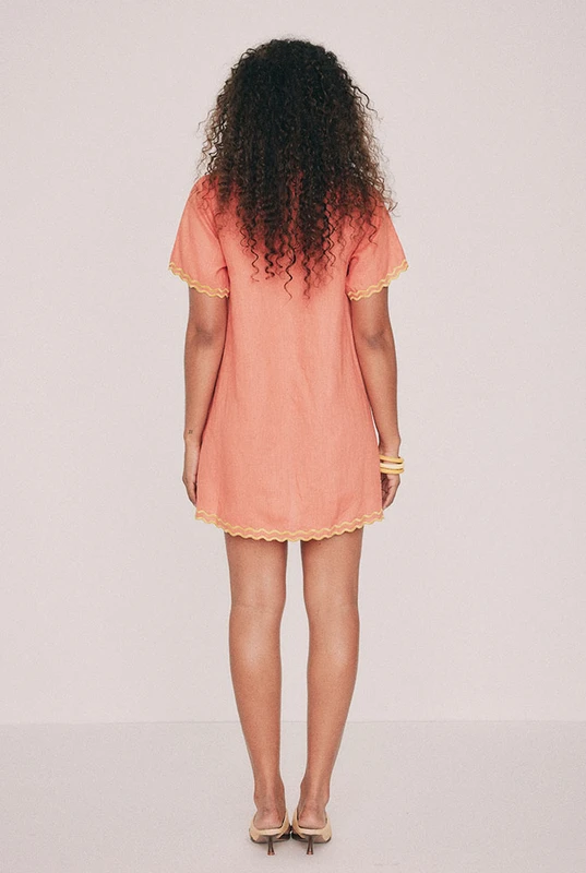 Cut from premium linen, this coral mini shirt dress is traced with hand-drawn tropical embroidery along a scalloped silhouette. Straight through the body with short sleeves, it buttons the whole way down, so it works as a dress, as a jacket over a slip, or thrown over swimmers on the walk back from the water. True to size, designed from a 6 to a 22.