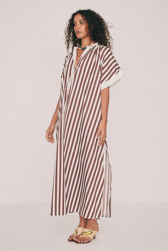 Cut from crisp cotton poplin, this brown striped maxi dress is oversized with wide grown-on sleeves. A mandarin collar buttons to the neckline or opens to the chest, while side splits and side pockets lend ease. Nothing is fitted anywhere, which is rather the point and makes it a continued best seller. Intended to be oversized. Designed from a 6 to a 22.