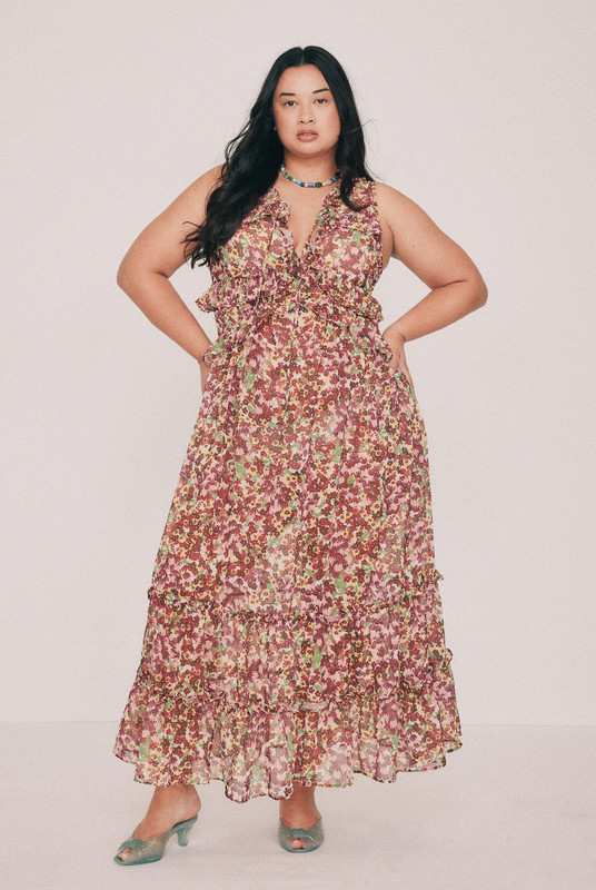 Cut from soft crepe georgette, this printed maxi dress skims the bust and waist before loosening through the hip. Ruffles run beneath the bust, at the waist and along the hem, while a low V neckline ties at the front with self rouleau. The Ola ditsy floral was drawn by hand in our Central Coast studio. Pockets sit in the side seams. A wedding guest dress that will also carry a long lunch. Pair with a vintage platform and chandelier earrings. Designed from a 6 to a 22.