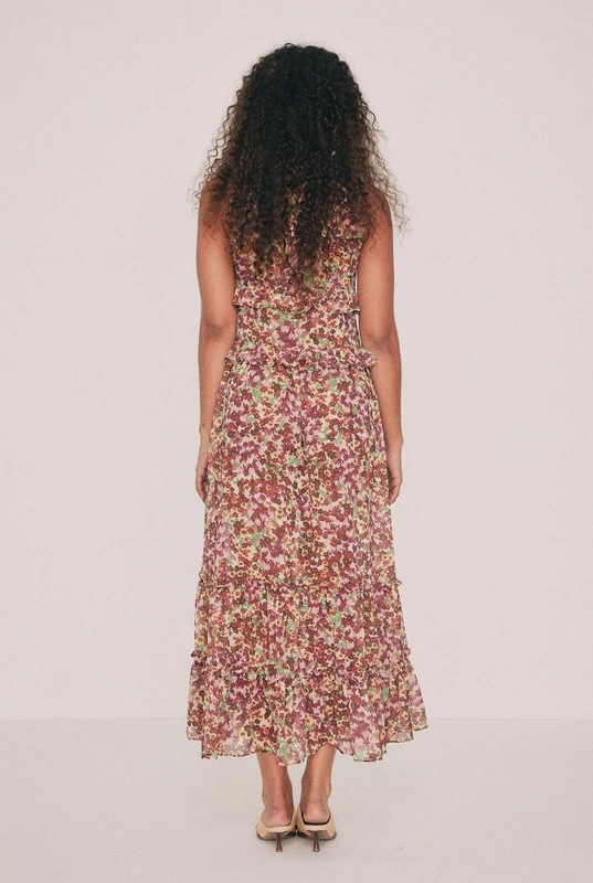 Cut from soft crepe georgette, this printed maxi dress skims the bust and waist before loosening through the hip. Ruffles run beneath the bust, at the waist and along the hem, while a low V neckline ties at the front with self rouleau. The Ola ditsy floral was drawn by hand in our Central Coast studio. Pockets sit in the side seams. A wedding guest dress that will also carry a long lunch. Pair with a vintage platform and chandelier earrings. Designed from a 6 to a 22.