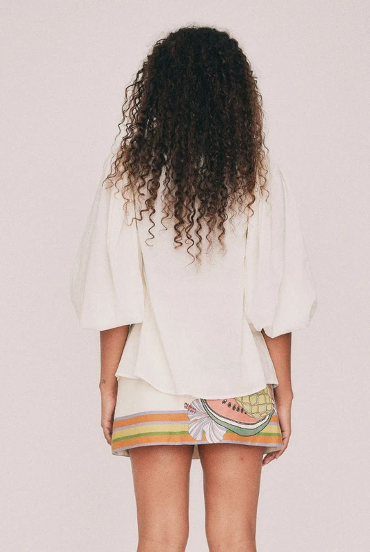 Cut from soft cotton voile, this cream blouse is finished with an embroidered collar designed in our Central Coast studio. Long puff sleeves gather at an elasticated cuff and the front buttons the whole way down. Tuck it into the Tropicana mini skirt, or wear it loose over denim shorts for a more casual approach. True to size, designed from a 6 to a 22.