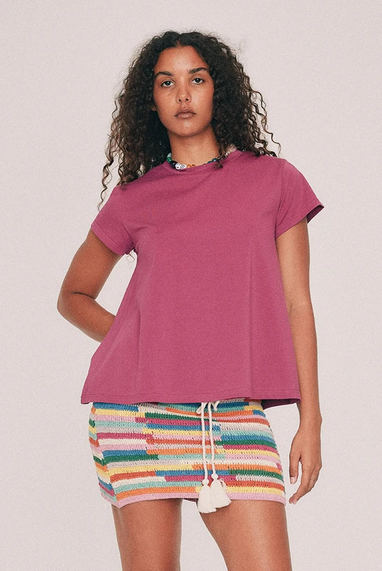 This fuchsia tee has a relaxed swing silhouette with cap sleeves. Machine washable and quietly indispensable: wear it with the crochet skirt all summer. Designed from a 6 to a 22.