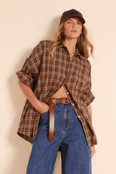 The oversized plaid shirt in a rich brown check is your go-to for laid-back layering. Cut from a soft, mid-weight fabric with drop shoulders and full sleeves, it’s perfect worn open over a dress or buttoned up with jeans for the ultimate casual-cool look.