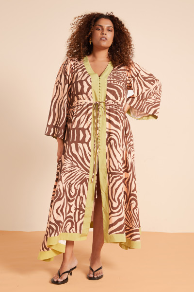 The Zebra Kaftan in peach is a statement in soft structure and bold print. Crafted from premium drape rayon in a custom Bohemian Traders design, it features a low V neckline, flared sleeves, and a tie belt to shape the silhouette. Effortless and eye-catching, it’s your go-to piece for sun-drenched days and sunset dinners.