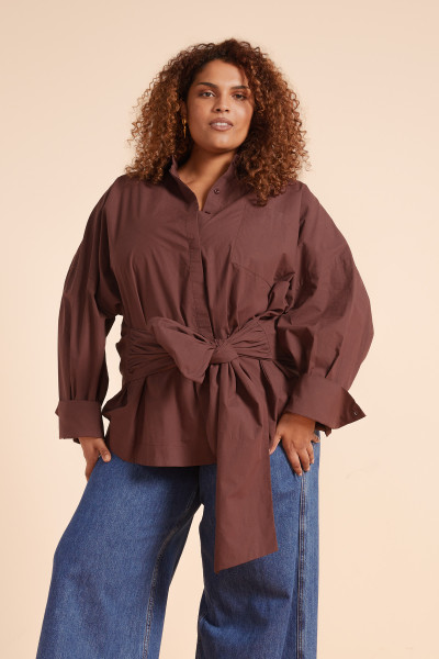 The Tie Waist Oversized Shirt in chocolate is cut from crisp cotton poplin and features a relaxed silhouette cinched at the waist with a self-tie belt. With a classic collar, full-length sleeves, and button-down front, it’s an elevated essential - wear it loose over denim or styled as a shirt-dress for laid-back polish.