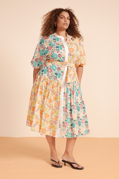 The Sundance Spliced Dress is a sunlit celebration of florals and flow. Crafted from soft cotton voile, this midi dress features balloon sleeves, a mandarin collar, and a tie waist to shape the silhouette. It’s a fresh, feminine ode to summer afternoons and terracotta streets.