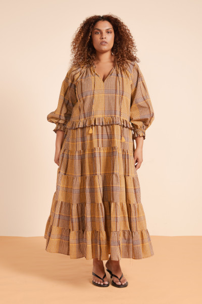 The Plaid Ruffle Neck Maxi is a love letter to timeless style, reimagined in rich chocolate check. Made from premium cotton, it features a ruffle collar with keyhole tie, full sleeves, and an easy, oversized silhouette. Designed for effortless wear through cooler days - just add boots and let the Torre Bennistra charm unfold.
