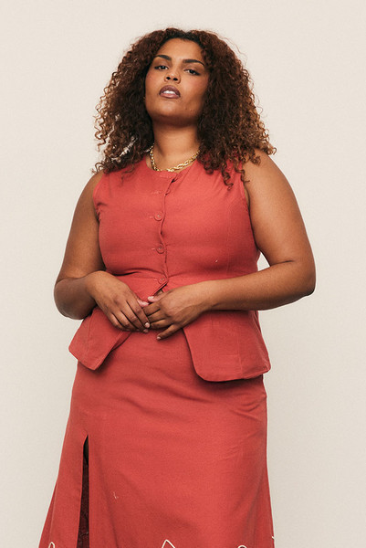 Tailored from a mid-weight linen blend, the Shaped Cotton Vest sculpts the form with confident ease. A modern classic defined by clean lines, subtle structure, and natural texture, it’s perfect worn alone or layered. Designed to carry you through the festive season, this piece channels effortless refinement and the quiet luxury of breathable natural fibres. Wear yours with the matching skirt or the Gingham Cropped Flare.