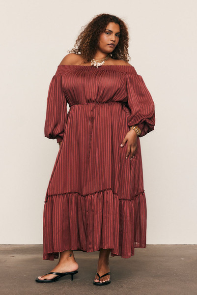 Luminous and luxurious, the Lurex Maxi Dress is crafted from a custom-dyed lurex-stripe blend, developed exclusively to Bohemian Traders’ exacting standards. Its off-shoulder neckline, voluminous balloon sleeves, and waist tie create a silhouette of effortless drama. Light-catching and fluid, it moves like liquid sunlight - a true statement of artistry and occasion-ready elegance.