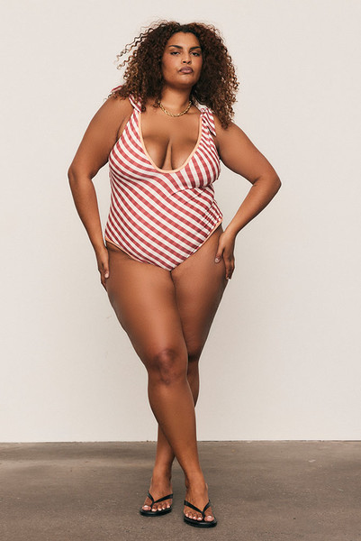 The Gingham V Neck Onesie is made from soft matte spandex with a custom Bohemian Traders print, designed to flatter every form. Featuring removable cups, tie straps, and full lining for structure and support, it offers confidence in motion. Pair with the Frayed Sarong for a coordinated, size-inclusive resort look that transitions beautifully from beach to bar.