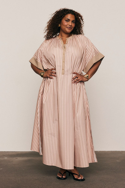 Crisp cotton poplin meets effortless movement in the Maxi Smock Dress. Showcasing Bohemian Traders’ custom pink striped print, this dress balances structure with ease through wide sleeves and a fluid silhouette. Designed to flatter every form, it’s the ultimate throw-on piece for sunny days and easy evenings.